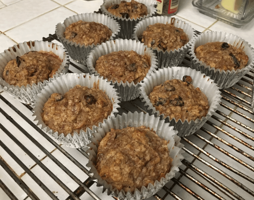 Gluten-free oatmeal muffins with apples, made without applesauce, displayed on a wooden board.